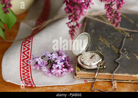 Antike Taschenuhr, Blume vor Holz- Hintergrund Stockfoto