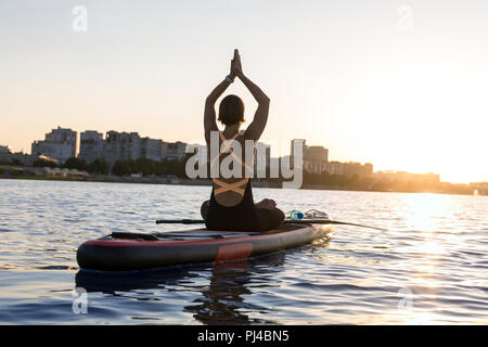Silhouette eines schlanken Mädchen in Yoga auf eine Stadt Hintergrund eingerückt Stockfoto