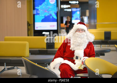 Colombier-Saugnieu (Frankreich): Flughafen Lyon Saint-Exupery. Santa Claus, Weihnachtsmann in einem Wartezimmer sitzen Stockfoto