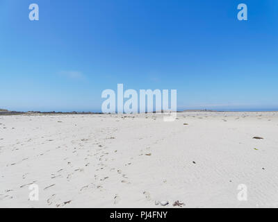 Ebbe auf Plage Sainte-Marguerite, Landeda, Bretagne, Fußabdrücke, kreuz und quer durch den Strand in Richtung kleine Inseln in der Ferne. Stockfoto