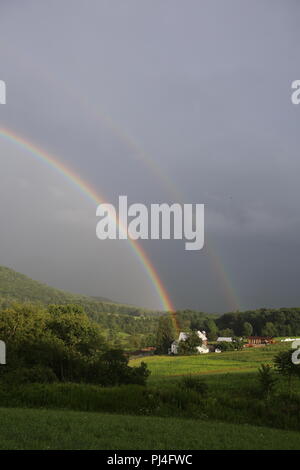 Doppelter Regenbogen über dem Bauernhof Berg Stockfoto