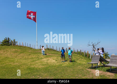 Menschen mit einer Flagge der Schweiz auf dem Mt. Rigi in der Schweiz Stockfoto