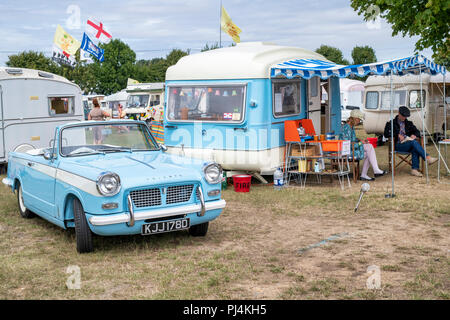 1966 Triumph Herald 1200 und ein Vintage caravan zu einem Vintage Retro Festival. Großbritannien Stockfoto