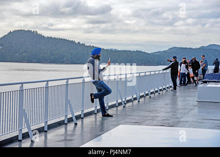 Passagier in chalm mit Telefon auf dem Deck, Fähre, Vancouver, Victoria, Kanada Stockfoto