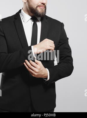 Ernsthafte Geschäftsmann sein Cuff Link auf der Hülle der Shirt Stockfoto