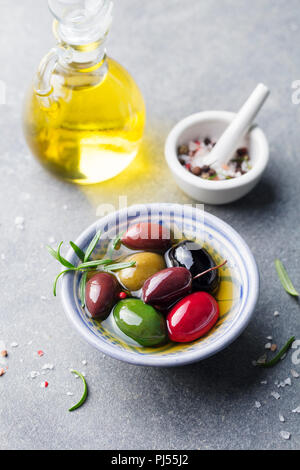 Oliven Sortiment in der Schüssel mit Öl. Stein Hintergrund. Stockfoto