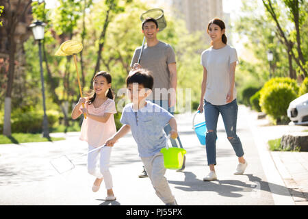 Glückliche junge Familie mit schmetterlingsnetze im Freien Stockfoto
