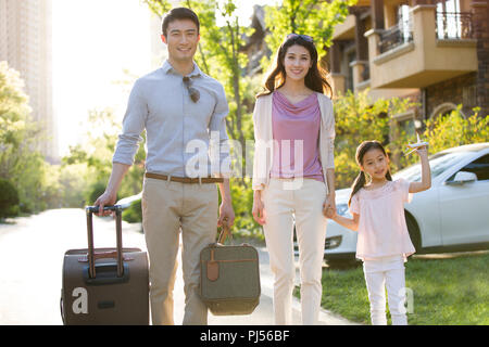 Glückliche junge Familie gehen für Urlaub Stockfoto