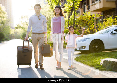 Glückliche junge Familie gehen für Urlaub Stockfoto