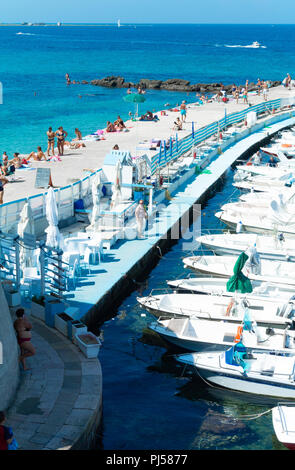 Italienische Volk an einem öffentlichen Strand am Hafen mit Yachten und Boote, Gallipoli, Lecce, Italien Stockfoto