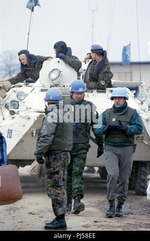 8. März 1993 während der Belagerung von Sarajevo: In der Nähe des Terminal am Flughafen von Sarajevo, ein norwegischer Kapitän Gespräche mit einem französischen Soldaten, wie sie sich von einem geparkten Ukrainischen BTR-80 APC-Spaziergang, seine Besatzung an Bord. Stockfoto