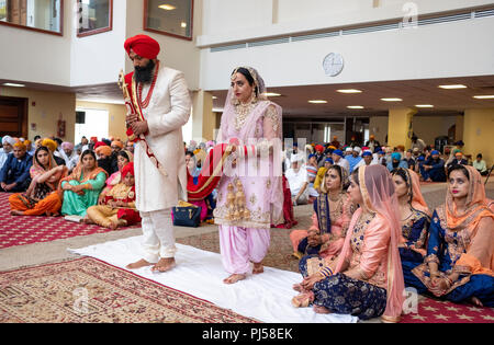 Ein Sikh Braut und Bräutigam in einem Tempel während ihrer Trauung. In Queens, New York City Stockfoto