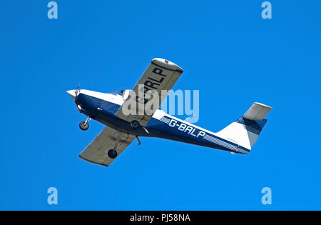 Ein tomahawk PA 38-112 auf einem fliegenden Lektion üben Note und geht Stromkreise am Flughafen Inverness im Norden Schottlands. Stockfoto