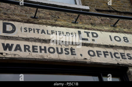 Alte der 1930er Jahre kommerzielle Schilder an der Wand durch Spitalfields Kirche in der City of London, UK Stockfoto