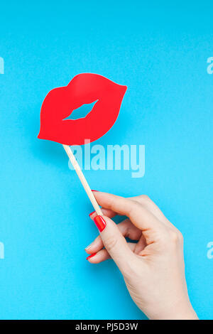 Kreative overhead Draufsicht retro stilvolle rotes Papier Photo Booth Requisiten weibliche Lippen in der Hand türkis Background Copy space. Geburtstagsfeiern und Hochzeiten Stockfoto