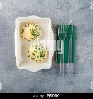 Muffins Eier mit Fisch und Grüns in einem Karton auf einem grauen Hintergrund. Gesundes Essen. Weg für Ernährung. Ansicht von oben. Stockfoto