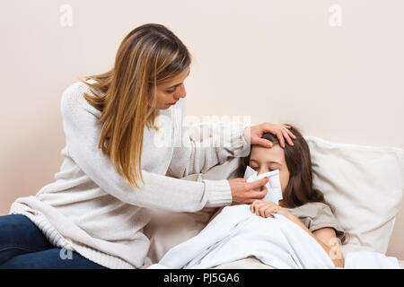 Kleine Mädchen mit Grippe und die Mutter kümmert sich um Ihre Stockfoto