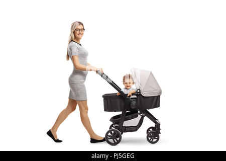 In voller Länge Porträt einer jungen Mutter treibt ein Kinderwagen mit einem Baby auf weißem Hintergrund Stockfoto