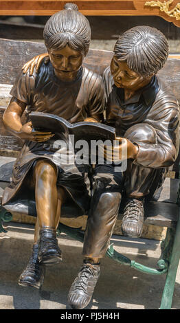 Bronze Skulptur von zwei Kindern auf einer Bank sitzen, ein Buch lesen in Chinatown San Francisco genommen Stockfoto