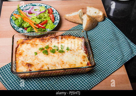 Lasagne im Gericht mit Salat und Brot Stockfoto