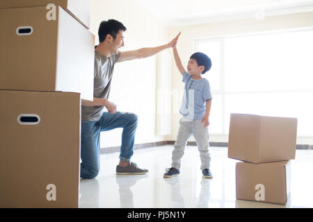 Glückliche junge Vater und Sohn nach Hause bewegen Stockfoto