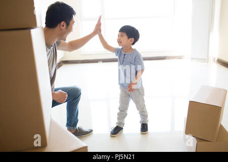 Glückliche junge Vater und Sohn nach Hause bewegen Stockfoto