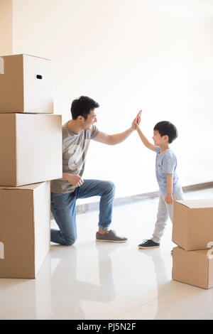 Glückliche junge Vater und Sohn nach Hause bewegen Stockfoto