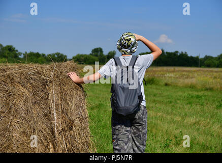 Jugendlich mit Rucksack steht von Stroh zu Stapeln Stockfoto