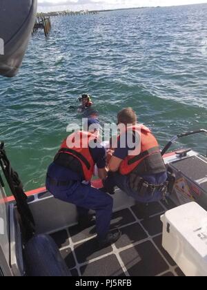 Coast Guard Station Islamorada 33-Fuß-Special Purpose Craft-Law Durchsetzung boatcrew Mitglieder begeben sich Robert Vonnegut an Bord ihrer Kleinboot- 12.08.27, 2018 in der Nähe von Tavernier, Florida. Die boatcrew und eine Küstenwache Air Station Miami MH-65 Hubschrauber Crew ging die Suche nach Vonnegut nach watchstanders bei Coast Guard Sektor Key West einen Bericht aus, der Sohn von Vonnegut erhalten, seinem Vater von Sunrise Drive gewichen und hatte nicht zurückgegeben. (Küstenwache Foto) Stockfoto