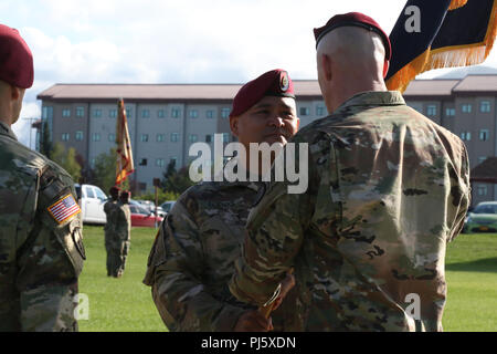 Command Sgt. Maj. Robert Duenas leitet die Einheit Farben zu der Brigade Kommandeur, Oberst Jason Jones während der 4 Infantry Brigade Combat Team (Airborne), 25 Infanterie Division Wechsel der Verantwortung Zeremonie 28 Aug., 2018 Pershing Feld, Joint Base Elmendorf-Richardson, Alaska. Stockfoto