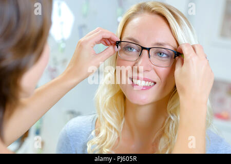 Junge weibliche Client versucht, auf Gläsern bei optischen Speichern Stockfoto