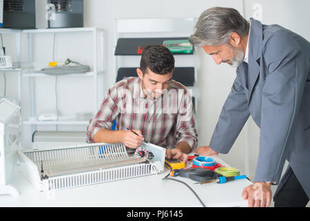 Manager prüfen Klempner des Wärmetauschers anschließen Stockfoto