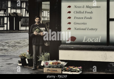 Asiatischer Ladenbesitzer außerhalb seiner Ecke shop, England, UK posing Stockfoto