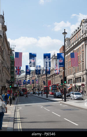 Viel befahrenen Straße Szene in Piccadilly, London. Werbebanner für die NFL und die Britische und Amerikanische Flaggen hängen über der Straße. England, Großbritannien Stockfoto