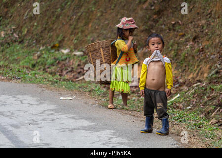 Ha Giang, Vietnam - März 17, 2018: Kinder der Hmong nomadischen Bevölkerung, landwirtschaftliche Arbeiten in den Bergen im Norden von Vietnam Stockfoto