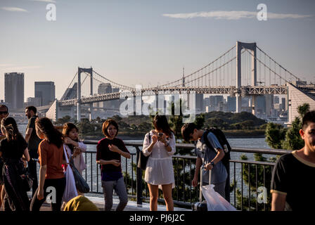 Tokio, Japan. 05 Sep, 2018. 05.09.2018, Tokyo, Japan: Passanten, die zu Fuß vor der Rainbow Bridge und die Skyline von Tokio in der Bucht Zone, wo zahlreiche Wettbewerbe bei den Olympischen Sommerspielen 2020 in Tokio statt. Fast zwei Jahre vor der nächsten Spiele, die Veranstalter präsentierten den Stand der Vorbereitungen für die Übereinstimmungen mit der internationalen Medien. Die ultra-modernen Tokyo Bay Zone wird der Mittelpunkt der Sommerspiele. Medaillen werden in 33 Sportarten vergeben, plus Baseball/Softball, Karate, Skateboard, Sport Klettern und Surfen. Quelle: Michael Kappeler/dpa/Alamy leben Nachrichten Stockfoto