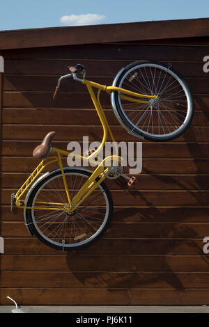 Moderne Fahrrad hängen an der Wand des Hauses außerhalb Stockfoto