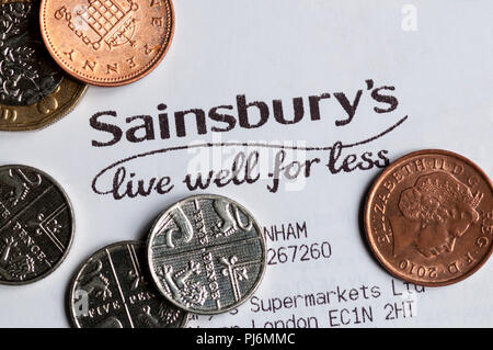 In der Nähe von Sainsbury's Leben gut für weniger Slogan auf einem kassenzettel mit Münzen gedruckt Stockfoto