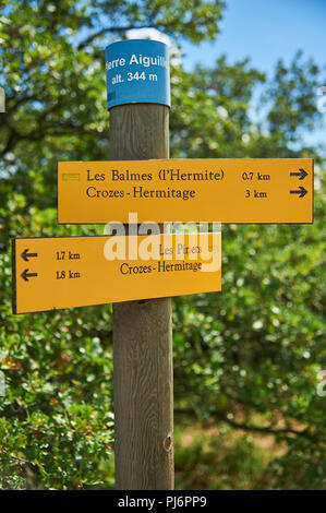 Gelbe fingerpost Zeichen auf einem Holz Pfosten auf dem Hügel oberhalb von Tain l'Hermitage im Departement Drome, Rhone Alpes, Frankreich Stockfoto