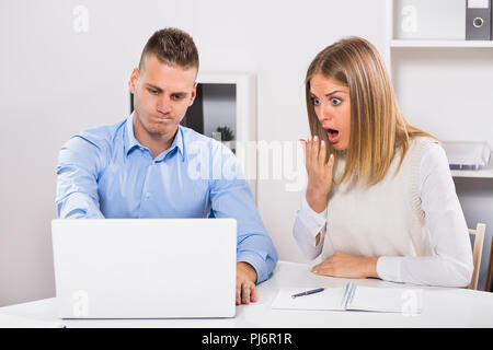 Besorgt, Geschäftsmann und Geschäftsfrau in Panik sind mit Laptop und die Arbeit in ihrem Büro. Stockfoto