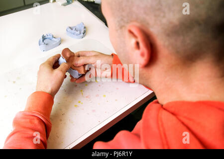 Arbeiten mit Schellack Grundplatten. Zahnersatz. Zahnersatz, Prothesen, Prothetik arbeiten. Zahntechniker im Prozess der Herstellung von Zahnersatz. Stockfoto