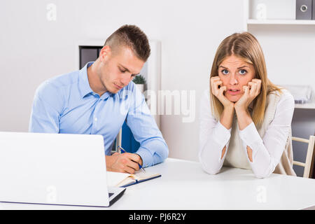 Unternehmer interviewt junge Frau Kandidat für den Job und sie ist besorgt, sie denkt, dass Interview nicht gut gehen. Stockfoto