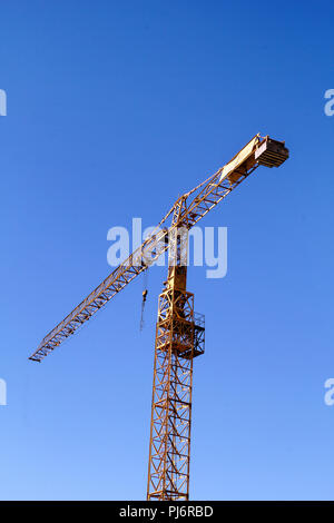 Yellow Crane Hoist. Yellow Crane Hebevorrichtung mit blauen Himmel im Hintergrund. Hebekran vor dem Hintergrund Himmel. Gelbe Bau tower Kran wieder Stockfoto