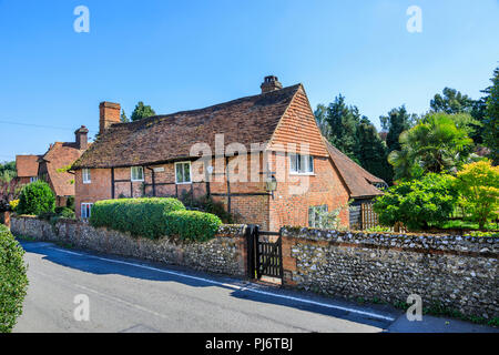 Ziemlich am Straßenrand redbrick Kirche Cottage mit Flint Stone Garden Wall im East Clandon, einem kleinen Dorf in der Nähe von Guildford, Surrey im Südosten Englands Stockfoto
