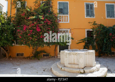 Kremasti Square, aka Parados Komninon mit einem venezianischen Brunnen in der Mitte, Campiello, Korfu, Griechenland Stockfoto