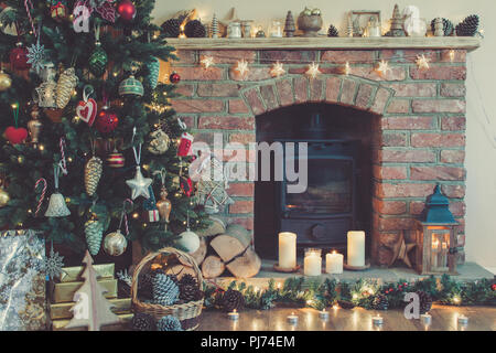 Schöne Weihnachten, dekoriert Kamin mit Kaminofen, beleuchtete Weihnachtsbaum mit Kugeln und Ornamente, Laterne, Sterne und Girlanden, selec Stockfoto