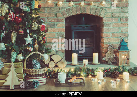 Schöne Weihnachten, dekoriert Kamin mit Kaminofen, beleuchtete Weihnachtsbaum mit Kugeln und Ornamente, Laterne, Sterne und Girlanden, selec Stockfoto