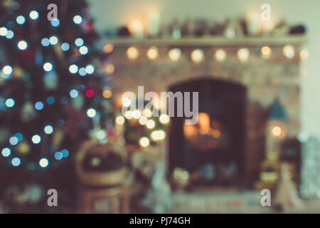 Abstrakte verschwommenen Hintergrund von Weihnachten, dekoriert Kamin mit Kaminofen, beleuchtete Weihnachtsbaum mit Kugeln und Ornamente, Laterne, Star Stockfoto