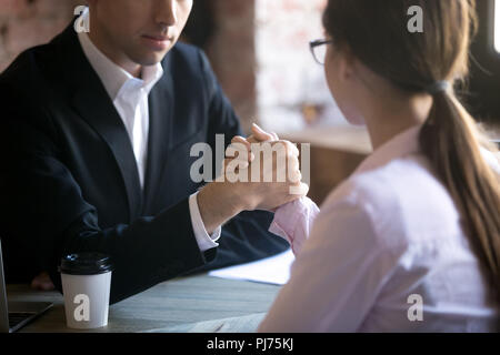 Ernster Mann und Frau armwrestling am Arbeitsplatz Stockfoto