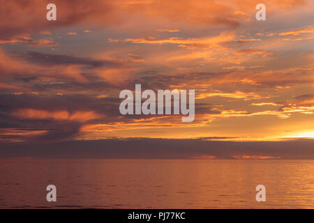 Dramatischer Sonnenuntergang Marine, Orange, Blau, Gelb, Magenta, gold Himmel im Meer Pazifik reflektiert, Hintergrund Foto von Sonne über Horizont ami Stockfoto